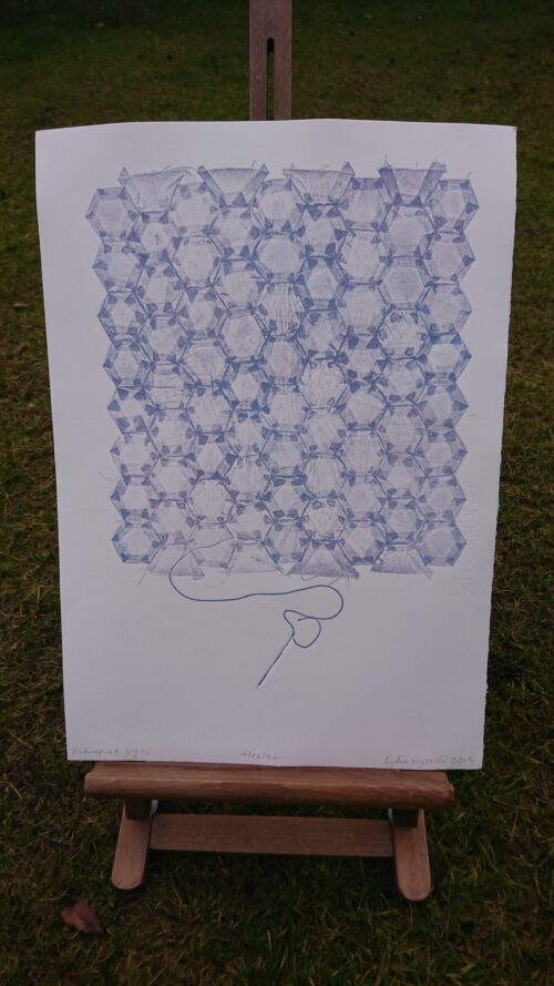 a photo of a honeycomb-style patchworked monoprint in lavender ink, outside on an easel